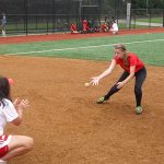 A pitcher and catcher do a softball drill together while at softball camp.