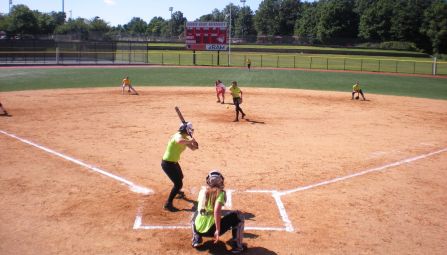 Aerial shot of a youth softball game from behind the catcher.
